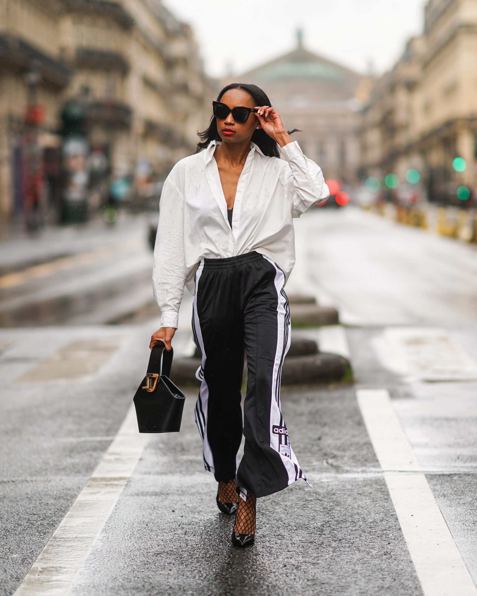 model walking in the road wearing sunglasses and handbag