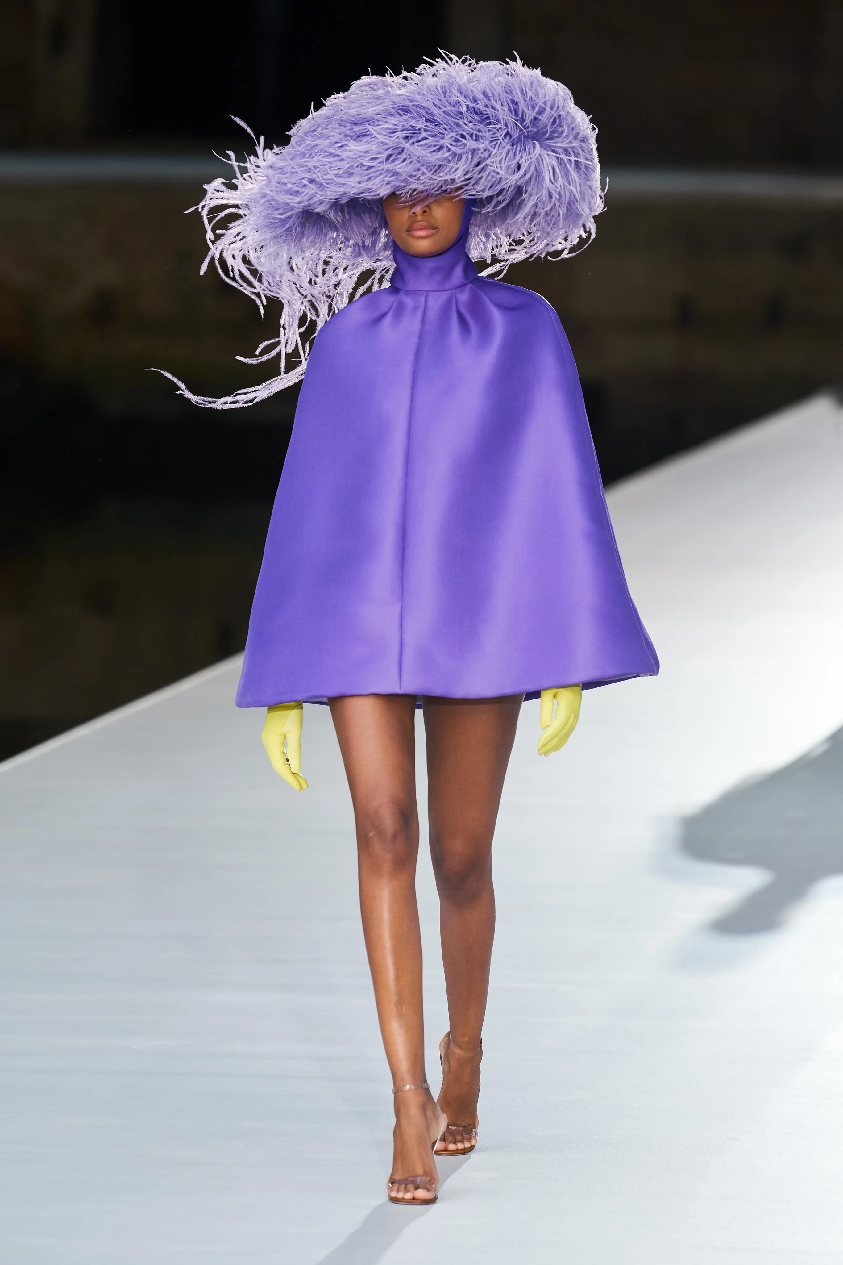 runway model wearing all purple with hat