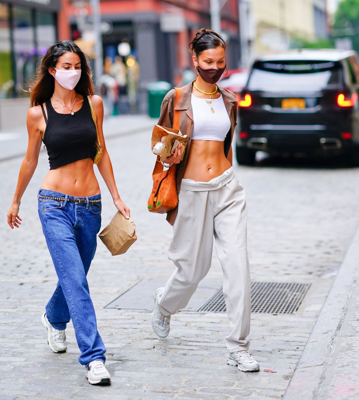 models walking in the road with a mask and low rise jeans