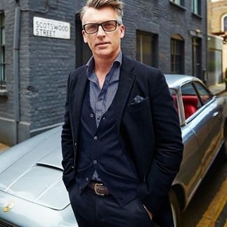 A-man-in-unstructured-blazers-standing-next-to-a-car