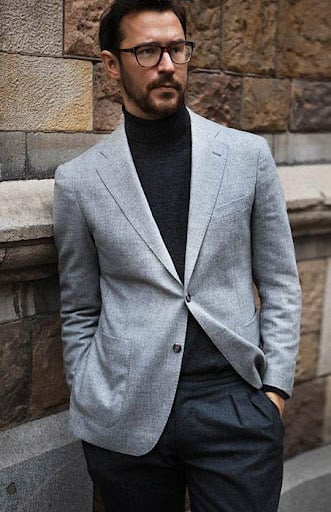 A-man-putting-on black-turtleneck-sweater-and-blazer