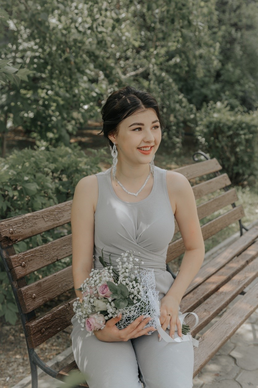 lady-sitting-on-park-bench-with-flowers-in-her-lap