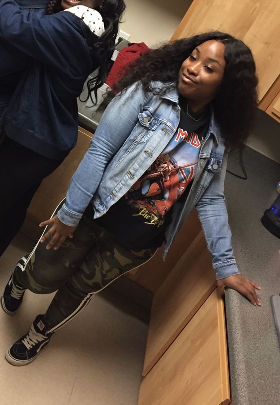 lady combines graphic tee with A Denim Jacket and camo pants