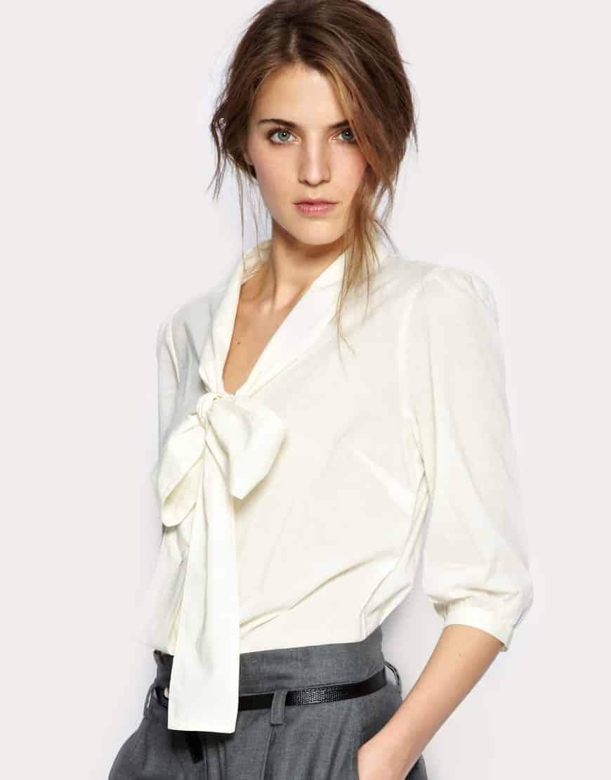 lady models in tie-neck blouse with low bow